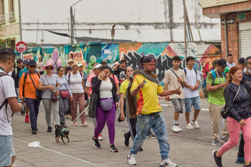 Caminata Tres Esquinas en Fusagasugá: Crónica, Ruta y Fotos (2026) 5 Caminante con camiseta de Colombia y ruana junto a su perro frente a murales urbanos de Fusagasuga