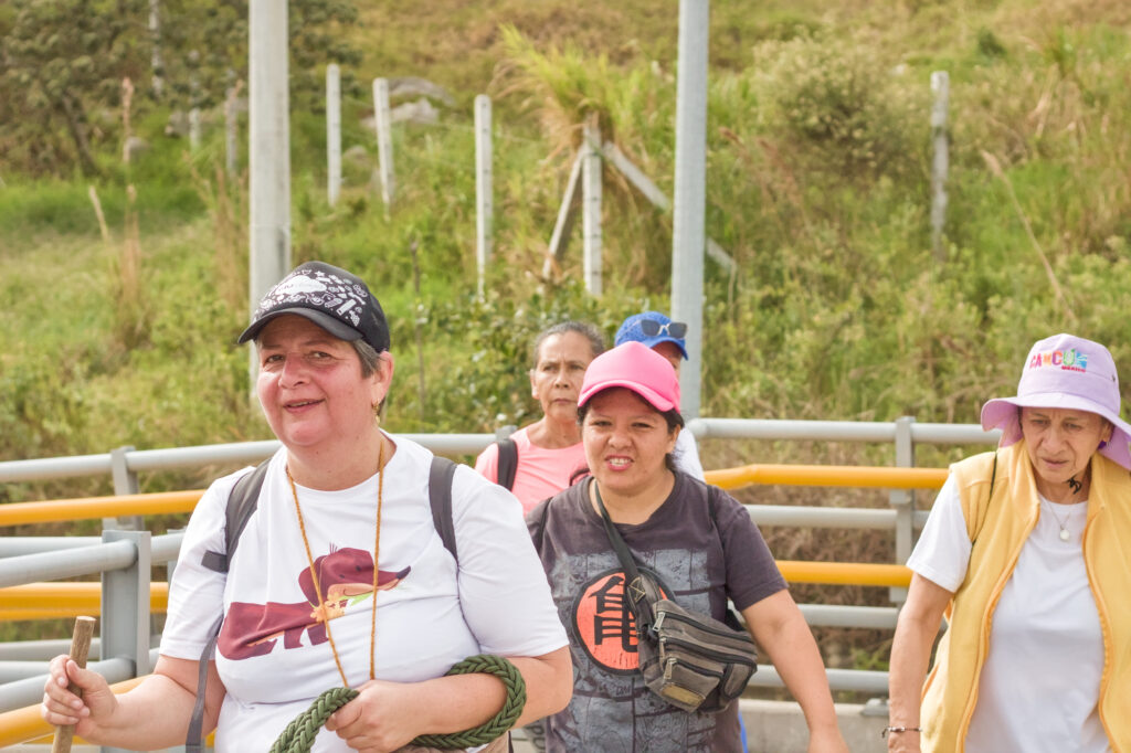 Caminata Tres Esquinas en Fusagasugá: Crónica, Ruta y Fotos (2026) 42 Caminante con camiseta de perro salchicha y bordon de madera subiendo el puente peatonal Cucharal