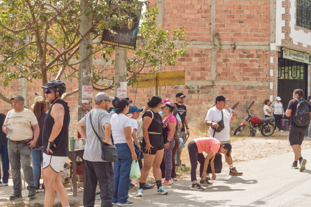 Caminata Tres Esquinas en Fusagasugá: Crónica, Ruta y Fotos (2026) 63 Senderistas haciendo estiramientos de piernas frente al minimarket La Canastica de Alis en Fusagasuga