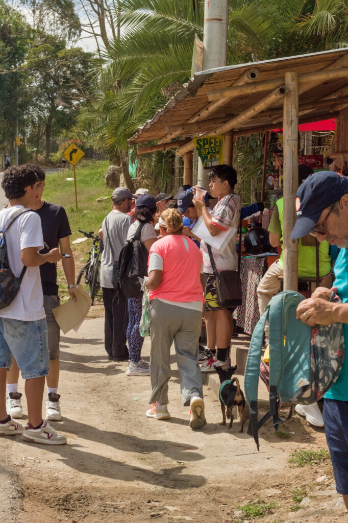 Caminata Tres Esquinas en Fusagasugá: Crónica, Ruta y Fotos (2026) 65 Fila de senderistas comprando bebidas frías en kiosco campesino de Vereda Novillero Fusagasuga